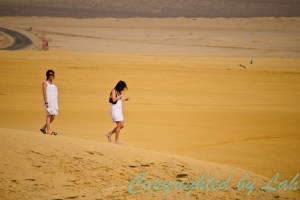 สองสาวนักท่องเที่ยวเดินชมความงามของทะเลทรายริมฝั่งมหาสมุทรของปารากัส